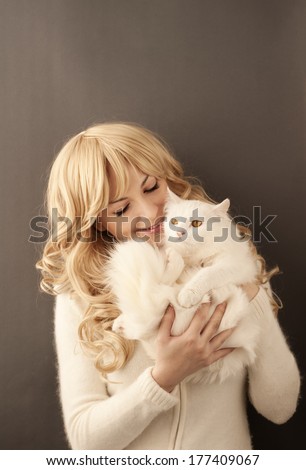 Pretty young woman holding white Persian cat