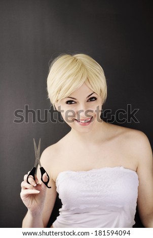 Pretty young woman with short hair holding scissors
