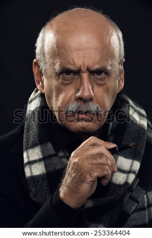 fine art portrait of an angry old man holding a pen in his hand.