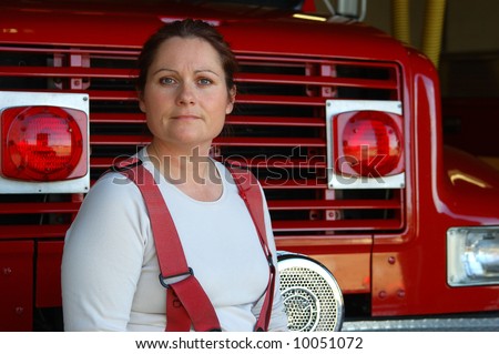 Female firefighter sitting on the front of a fire engine