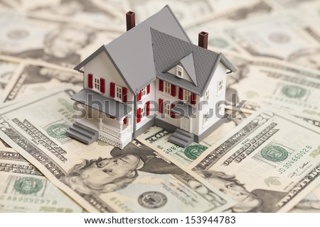 Single family house on pile of money. Concept of real estate.