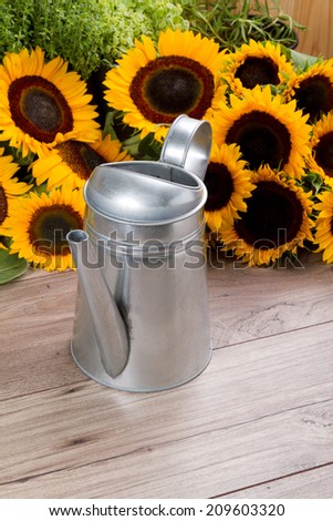 watering can and sunflowers
