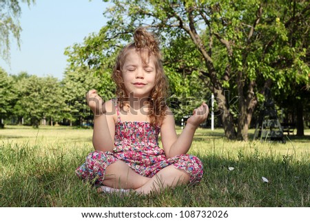 little girl meditates in nature