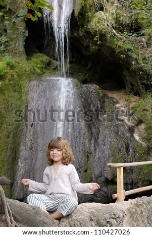 little girl meditates in nature