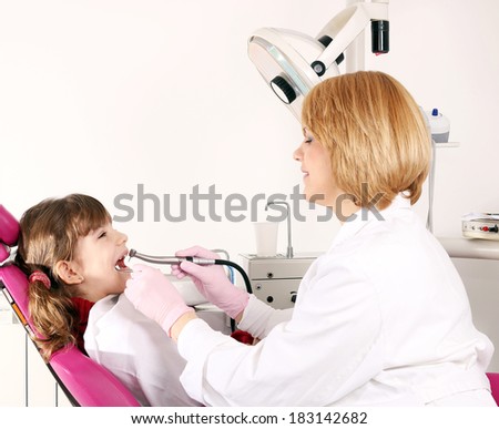 little girl and dentist drilling treatment
