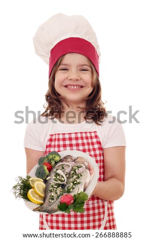 happy little girl cook with prepared trouts on plate