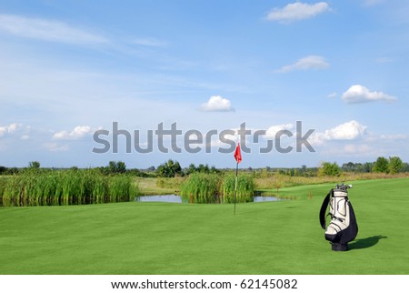 golf field with red flag and bag