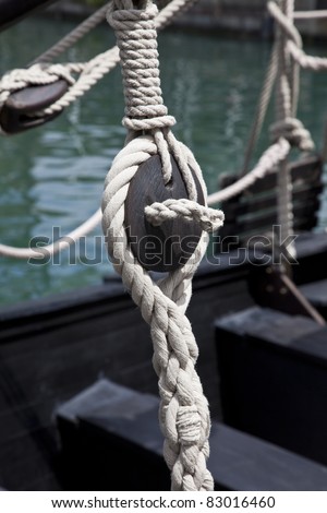 Pulley block on an old wooden sail boat with ropes