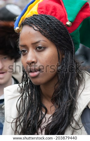JERUSALEM, ISRAEL - MARCH 15: Portrait of a young Ethiopian woman on her head wearing clown hat with bells. Purim is a Jewish holiday,  custom of masquerading  in costume and the wearing of masks.