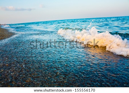 Soft sea ocean waves wash over sand background. Sunset, sunrise