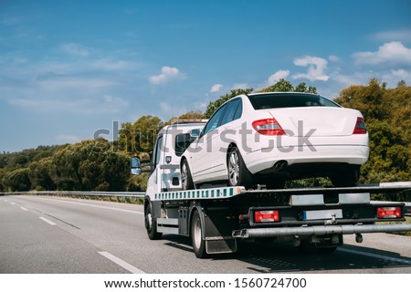 Car Service Transportation Concept. Tow Truck Transporting Car On Motorway Freeway Highway. Help On Road Transports Wrecker Broken Car. Transportation Faults And Emergency Cars. Stock foto © 
