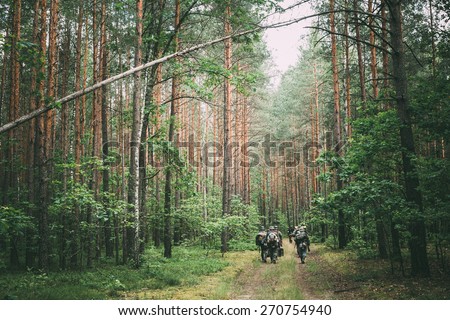 Unidentified re-enactors dressed as German soldiers during march through summer forest