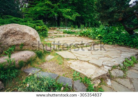 Stone Pathway Walkway Lane Path With Green Trees And Bushes In Garden. Beautiful Alley In Park