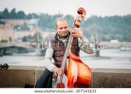 PRAGUE, CZECH REPUBLIC - OCTOBER 8, 2014: Street Busker performing jazz songs on the Charles Bridge in Prague. Busking is legal form of earning money on Prague Streets.