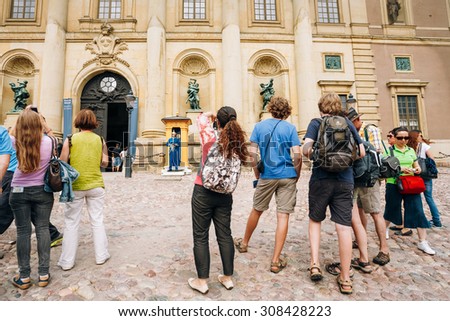 STOCKHOLM, SWEDEN - JULY 30, 2014: Tourists visit and photograph the guard of honor at the Royal palace in Gamla Stan, where king Carl XVI Gustaf has his working office.