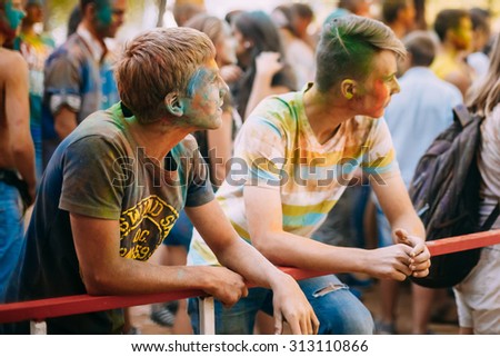 Gomel, Belarus - August 30, 2015: Two young men are standing together on background of crowd at Holi color festival in park