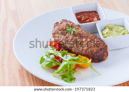 Fusion style fried pork and bread with red and green sauce.