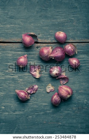 Shallots (red onion) set up on wood table with low key scene and vintage color tone