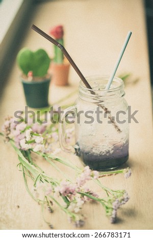 purple Italian soda on wood bar in cafe with film filter effect