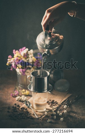 Vietnamese style drip coffee, Woman hand pouring hot water into metal coffee filter with film filter effect