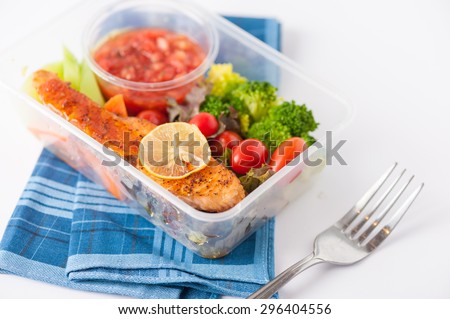 Grilled salmon with tomato salsa and salad cooked by clean food concept in lunch box