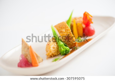3 modern cuisine Prosciutto Wrapped Chicken with resotto and tamarind sauce, Fried mussaman curry, and Thai chicken spicy sausage on ceramic dish garnished with vegetables