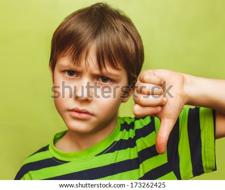 baby boy teenager showing thumbs down on the big green background large