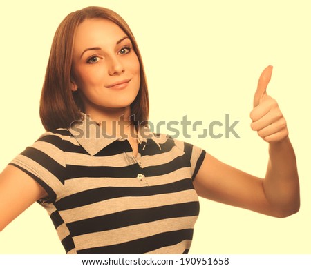 portrait happy woman young girl shows positive sign thumbs yes, in striped t-shirt isolated large cross processing retro