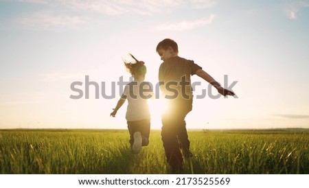 Similar – Image, Stock Photo Brother and sister playing on the field at the day time. Children having fun outdoors. They jumping on inflatable balls on the lawn. Concept of friendly family.