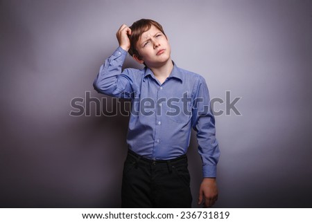 teenager boy scratching his head thinking