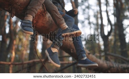 Similar – Image, Stock Photo Baby legs dangling from high chair; baby wearing turquoise outfit with bare feet against white wood background