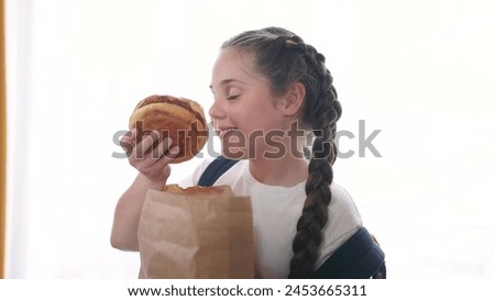 Similar – Foto Bild Hübsches Schulmädchen isst Hamburger und sitzt drinnen in einem Cafe. Glückliches Kind, das Junkfood in einem Restaurant isst. Seitenansicht