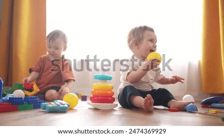 Similar – Image, Stock Photo Toddler playing with a colorful plastic bug toy; using hands to manipulate small object developmental milestone