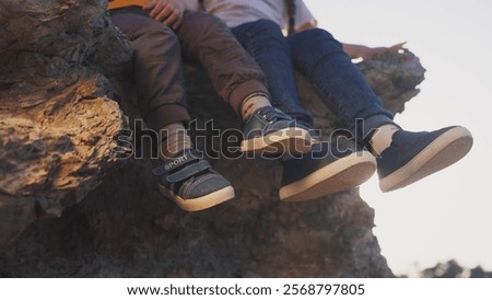 Similar – Image, Stock Photo Baby legs dangling from high chair; baby wearing turquoise outfit with bare feet against white wood background