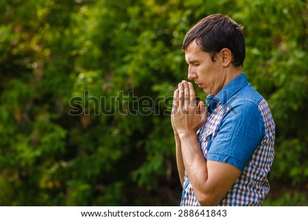 The man in the street to pray to God on a green background leaves summer