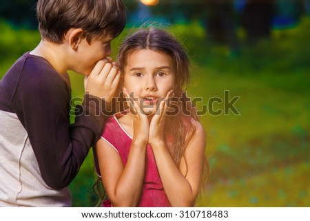 boy girl whispers in the ear secret rumors says in nature photos sunlight