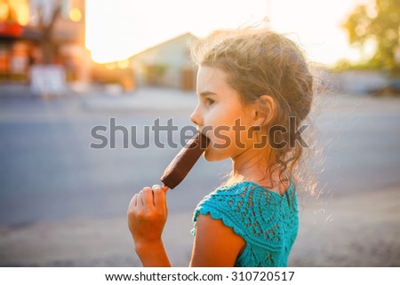 girl child eating ice cream  outside a side view sunlight