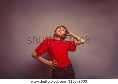 Boy, teenager, twelve years in  red shirt, thoughtful, derzhet head hand behind his retro