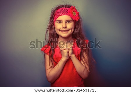 teen girl of European appearance five years the joy of surprise on  a gray  background retro