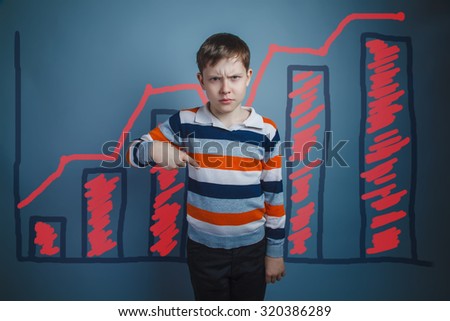 Boy angry guy serious teen shows the finger draws a symbol chart sales growth infographics studio blue background