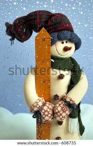 Snowman standing in the snow bank against a blue starry background.