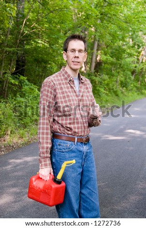 Upset man holding a gas can on a country road, flipping the bird.