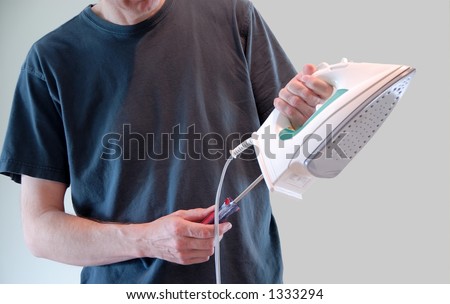 A man repairs a broken clothes iron using a screwdriver.
