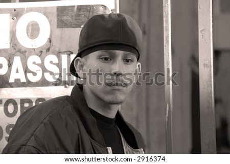 No Trespassing - A teenage Latino boy in front of a no trespassing sign