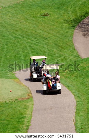 Golfers - Golfers using golf carts to get around the golf course.