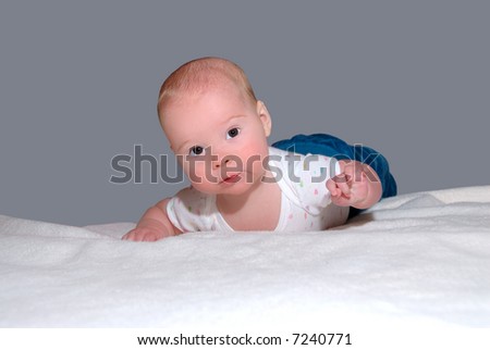 Brown Eyed Baby - A brown eyed baby with a sweet expression at 4 months old lying on her stomach on a blanket.  Learning to hold her head up.
