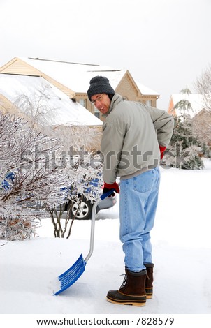 Man Shoveling Snow - A man shoveling snow on a cold, icy winter day.
