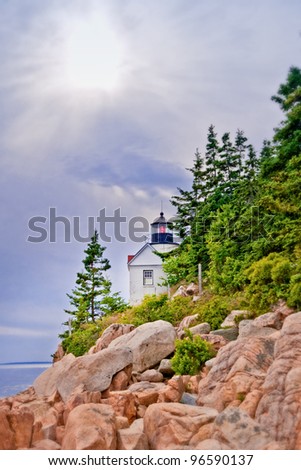 Bass Harbor Head Lighthouse in Maine USA can be seen at the by hiking along a hillside of boulders along the Atlantic Coast.