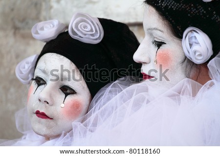 VENICE, ITALY - MARCH 7: An unidentified masked woman and child pose in front of St. Mark church in Venice, Italy on March 7, 2011 during the annual Venice carnival. The carnival is from February 26 - March 8, 2011.