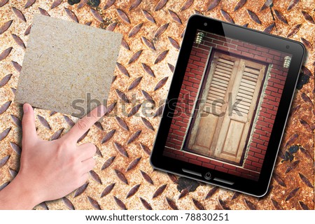 touch pad with old door background and recycle paper on hand: grunge rusty plate